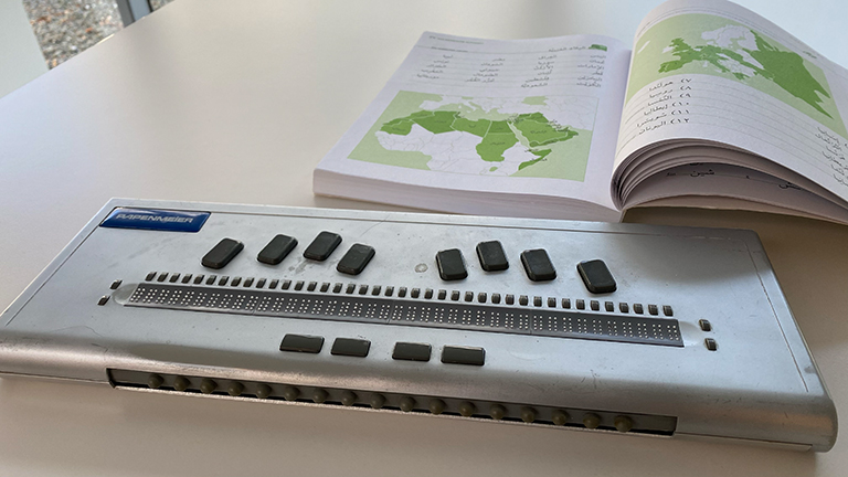 Leons Braille-Tastatir, im Hintergrund das Arabisch-Lehrbuch des LSI